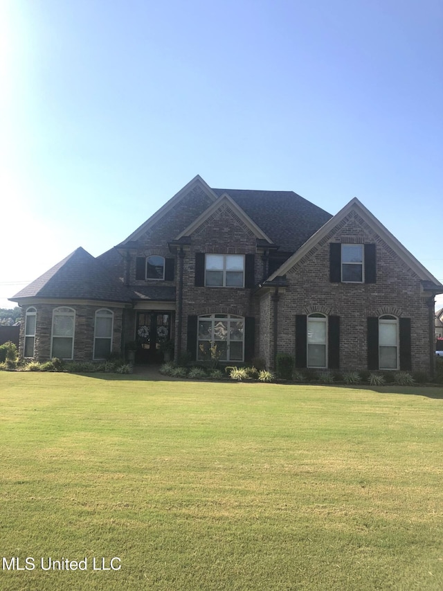 view of front facade featuring brick siding and a front lawn