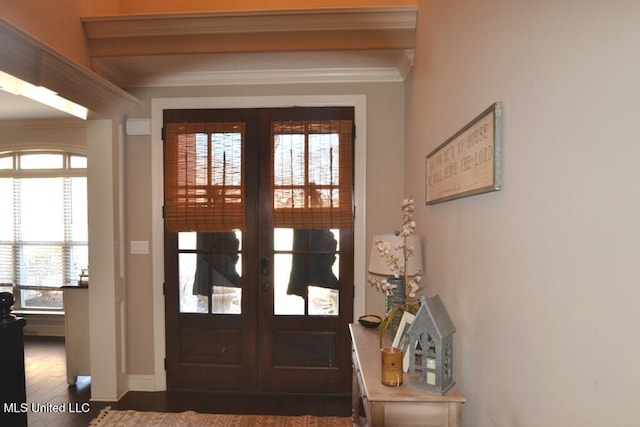 doorway featuring dark wood-style floors, baseboards, ornamental molding, and french doors