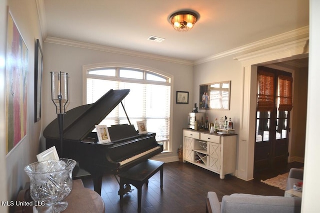 sitting room with ornamental molding, visible vents, and dark wood-style floors