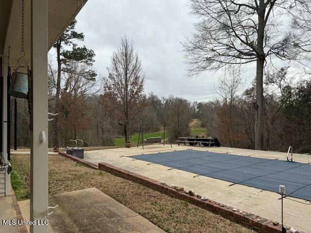 view of swimming pool featuring a patio area and a covered pool