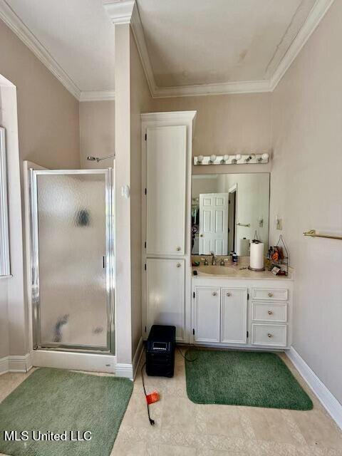 bathroom with ornamental molding, a shower stall, vanity, and baseboards