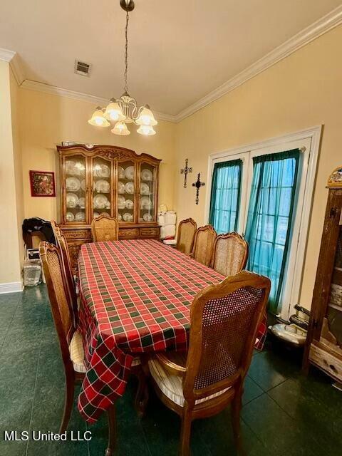 dining area featuring baseboards, ornamental molding, visible vents, and a notable chandelier