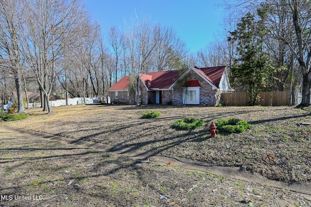 view of front of property featuring stone siding and fence