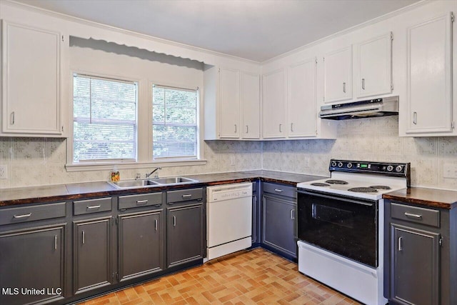 722 SE 1st St, Magee, MS 39111 - kitchen featuring dark countertops, under cabinet range hood, white cabinets, and white appliances
