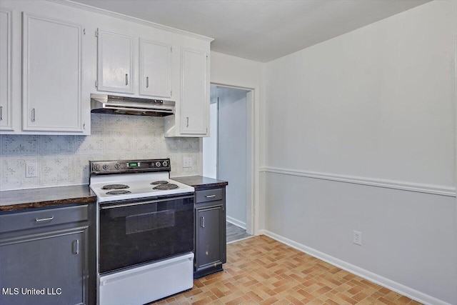 722 SE 1st St, Magee, MS 39111 - kitchen featuring electric range, dark countertops, white cabinetry, baseboards, and under cabinet range hood
