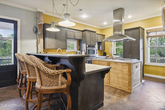 kitchen with island exhaust hood, kitchen peninsula, stainless steel appliances, crown molding, and a breakfast bar