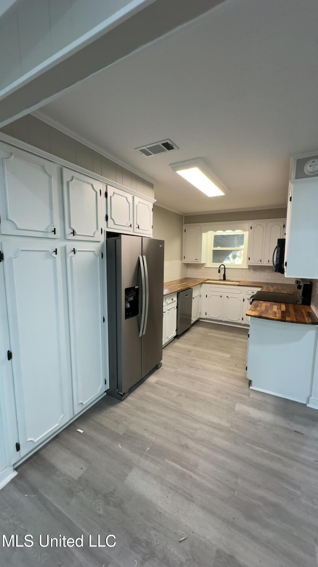 kitchen with visible vents, wooden counters, light wood-style floors, a sink, and black appliances