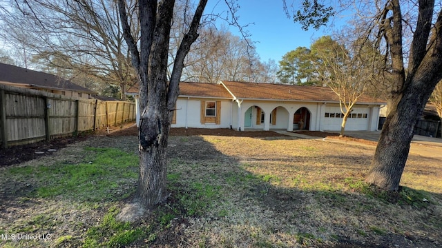 view of front of property with a garage, driveway, and fence