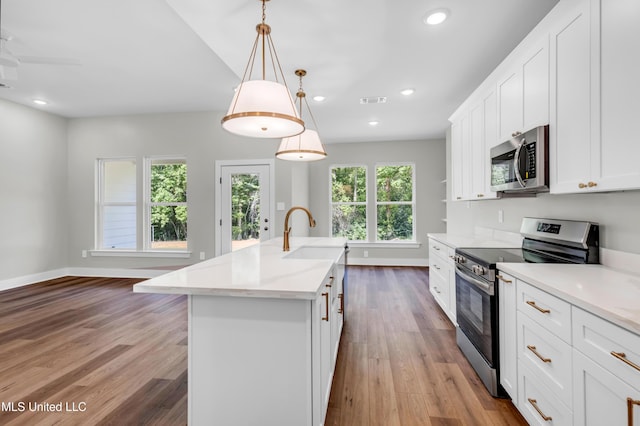 13379 Wash Fayard Rd, Biloxi, MS 39532 - kitchen with stainless steel appliances, a sink, dark wood-style flooring, a center island with sink, and baseboards