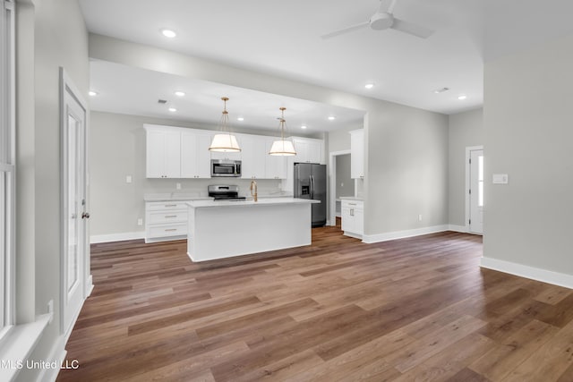 13379 Wash Fayard Rd, Biloxi, MS 39532 - kitchen featuring appliances with stainless steel finishes, ceiling fan, light wood-style flooring, white cabinets, and open floor plan