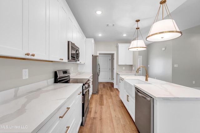 13379 Wash Fayard Rd, Biloxi, MS 39532 - kitchen with stainless steel appliances, light wood finished floors, recessed lighting, a sink, and a kitchen island with sink