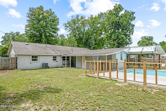 back of house with a fenced in pool, central AC, a patio, and a lawn