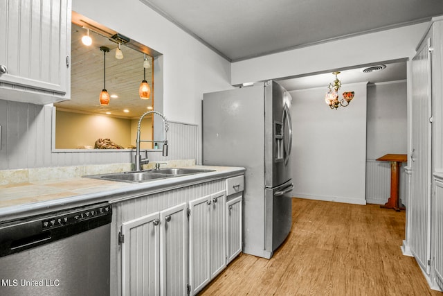 kitchen with light hardwood / wood-style flooring, stainless steel appliances, sink, and pendant lighting