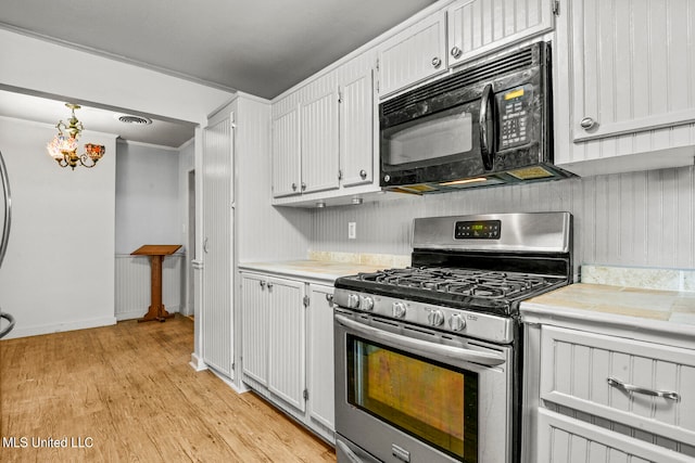 kitchen featuring stainless steel range with gas stovetop, light hardwood / wood-style floors, crown molding, and white cabinets