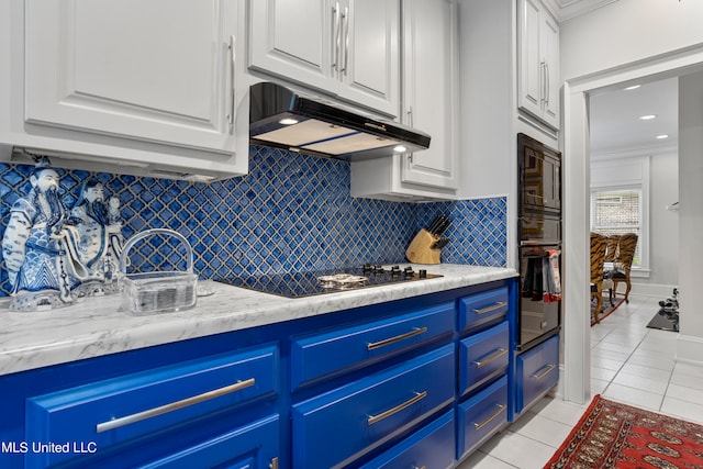 kitchen with blue cabinetry, black appliances, white cabinetry, and backsplash