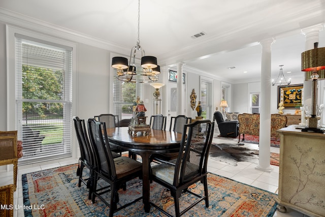 tiled dining area with decorative columns, ornamental molding, and an inviting chandelier