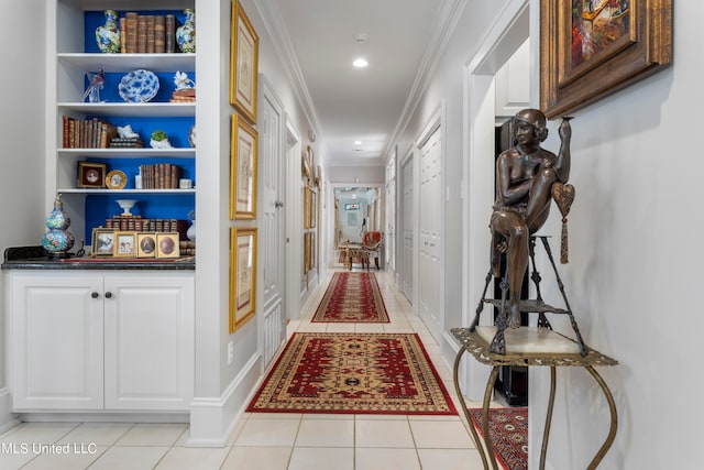 hallway with ornamental molding and light tile patterned floors