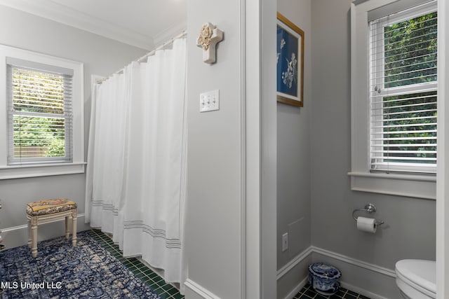 bathroom featuring toilet, crown molding, tile patterned floors, and plenty of natural light