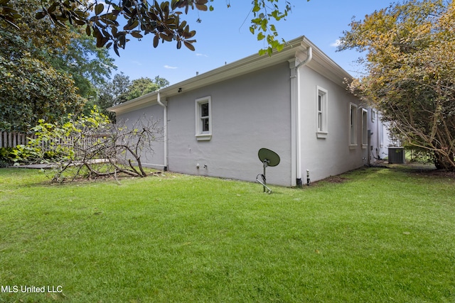 view of home's exterior with a yard and central AC unit