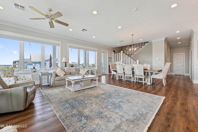 living room featuring ornamental molding, dark hardwood / wood-style floors, and ceiling fan with notable chandelier