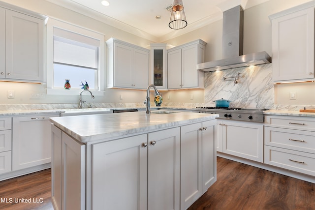 kitchen with white cabinets, an island with sink, dark wood-type flooring, wall chimney exhaust hood, and sink