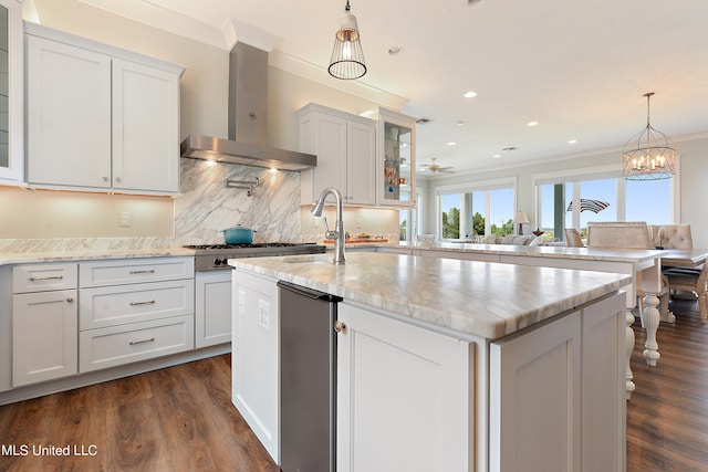 kitchen with white cabinetry, wall chimney exhaust hood, dark hardwood / wood-style flooring, and a kitchen island with sink