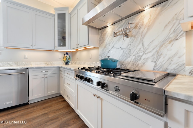 kitchen featuring wall chimney exhaust hood, appliances with stainless steel finishes, dark hardwood / wood-style floors, and white cabinets