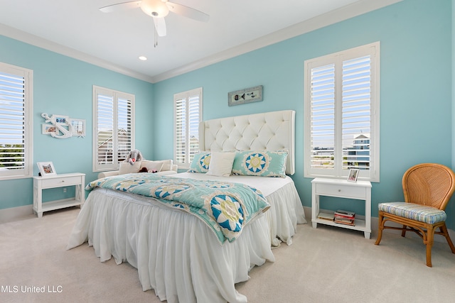 carpeted bedroom featuring ceiling fan, ornamental molding, and multiple windows