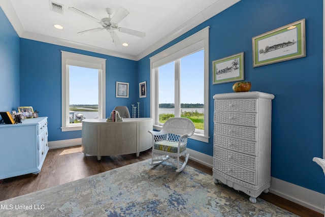 sitting room featuring dark wood-type flooring, crown molding, and ceiling fan