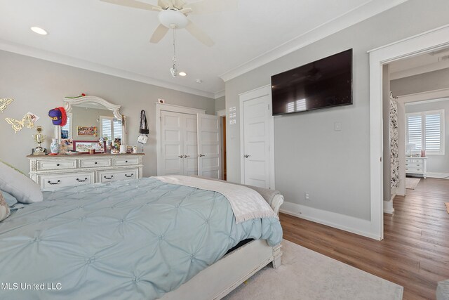 bedroom featuring light hardwood / wood-style flooring, a closet, crown molding, and ceiling fan