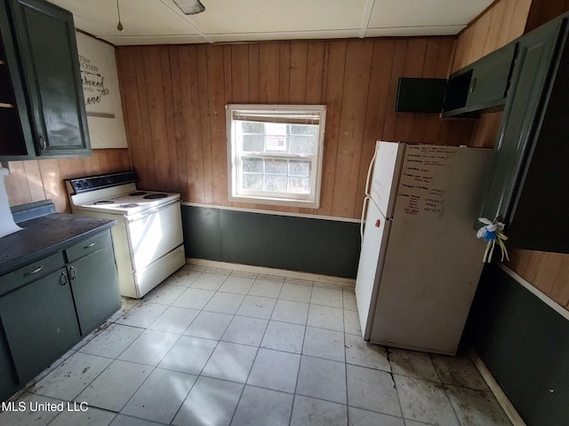 kitchen with a paneled ceiling, wood walls, and white appliances