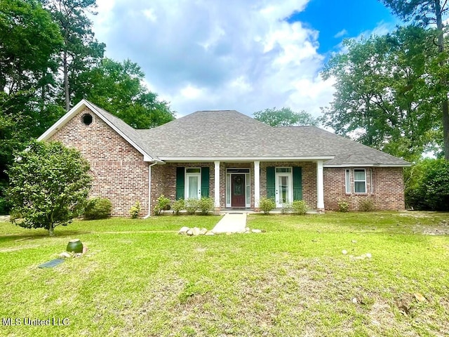 106 Peninsula Dr, Carriere, MS 39426 - view of front of property featuring brick siding, a front lawn, roof with shingles, and a porch