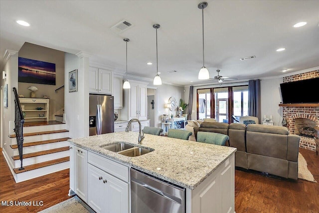 38 Savannah Cir, Brandon, MS 39047 - kitchen featuring stainless steel appliances, ceiling fan, white cabinetry, ornamental molding, and decorative columns
