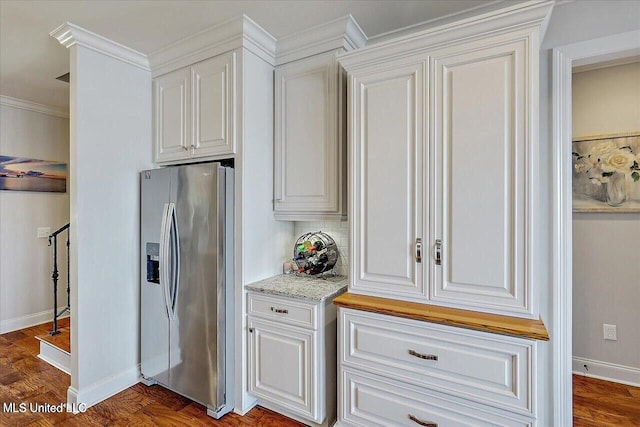 38 Savannah Cir, Brandon, MS 39047 - kitchen with stainless steel fridge, white cabinets, backsplash, light stone counters, and ornamental molding