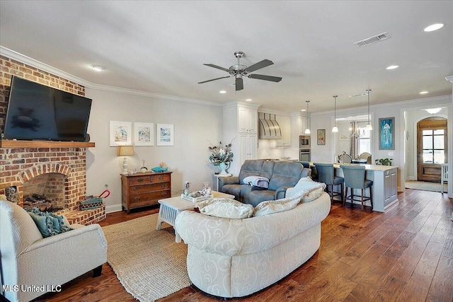 38 Savannah Cir, Brandon, MS 39047 - living area with a ceiling fan, dark wood-style floors, a fireplace, crown molding, and recessed lighting