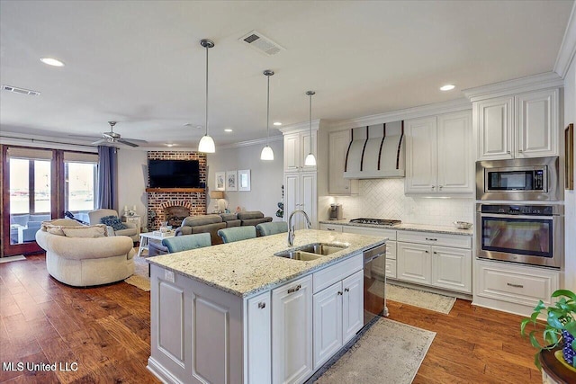 38 Savannah Cir, Brandon, MS 39047 - kitchen featuring stainless steel appliances, exhaust hood, white cabinetry, crown molding, and a ceiling fan