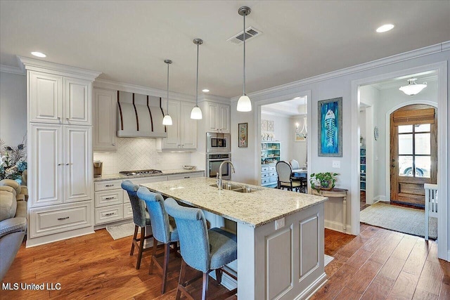 38 Savannah Cir, Brandon, MS 39047 - kitchen with appliances with stainless steel finishes, extractor fan, wood finished floors, light stone counters, and backsplash