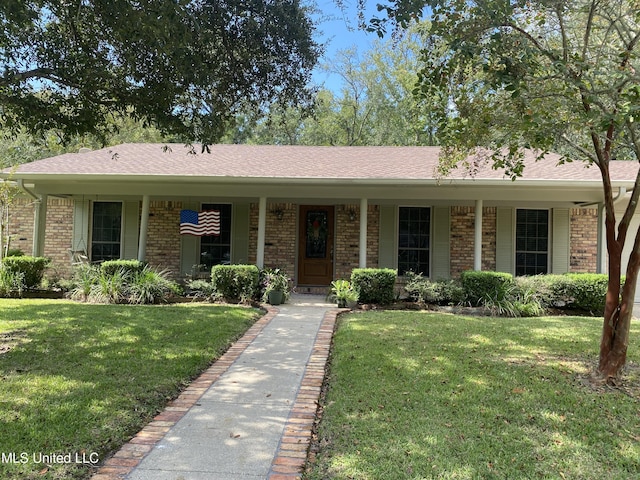 view of front facade featuring a front lawn, brick siding, and covered porch
