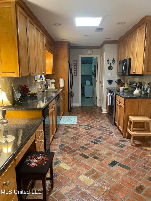 kitchen with ornamental molding, sink, appliances with stainless steel finishes, and tasteful backsplash