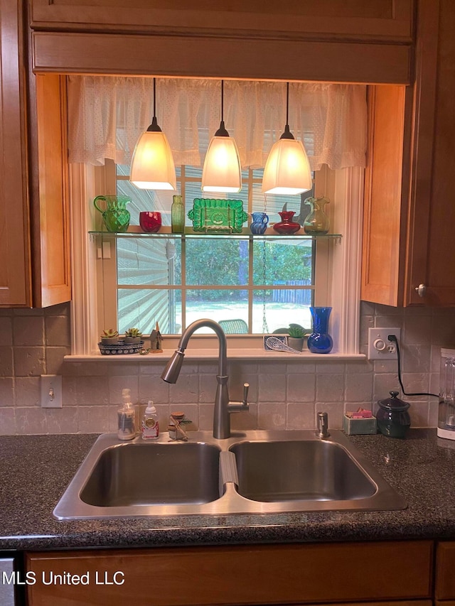 kitchen with decorative backsplash, sink, and hanging light fixtures