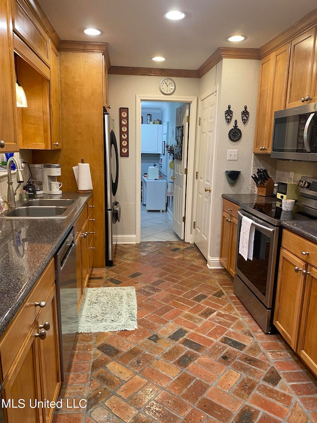 kitchen featuring stainless steel appliances, ornamental molding, and sink