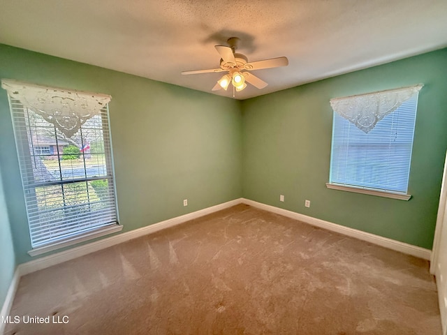 spare room with baseboards, a ceiling fan, and carpet flooring