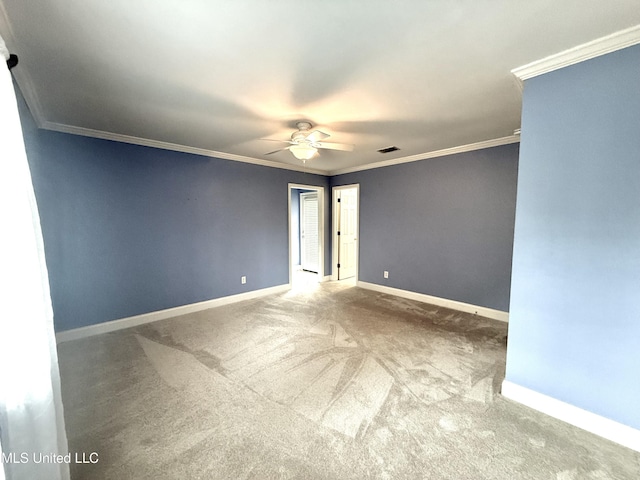 unfurnished room with visible vents, baseboards, carpet, a ceiling fan, and ornamental molding