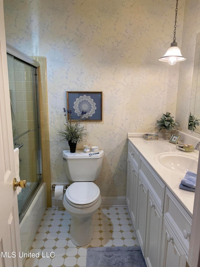 full bathroom with vanity, bath / shower combo with glass door, and toilet