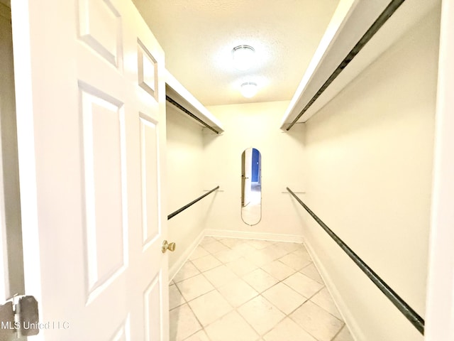 walk in closet with light tile patterned flooring
