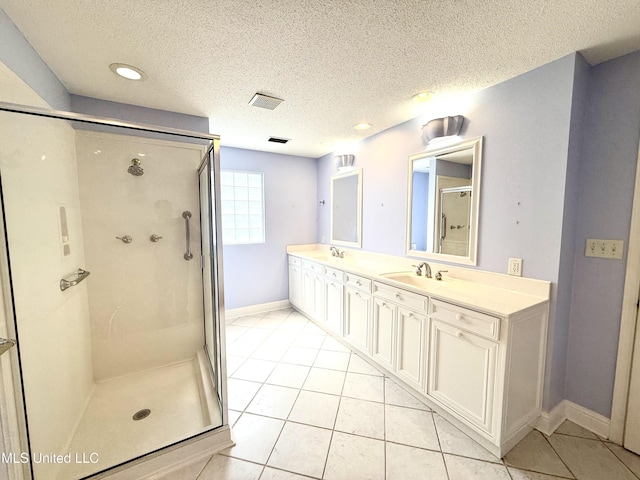 full bath with a textured ceiling, tile patterned flooring, and a stall shower