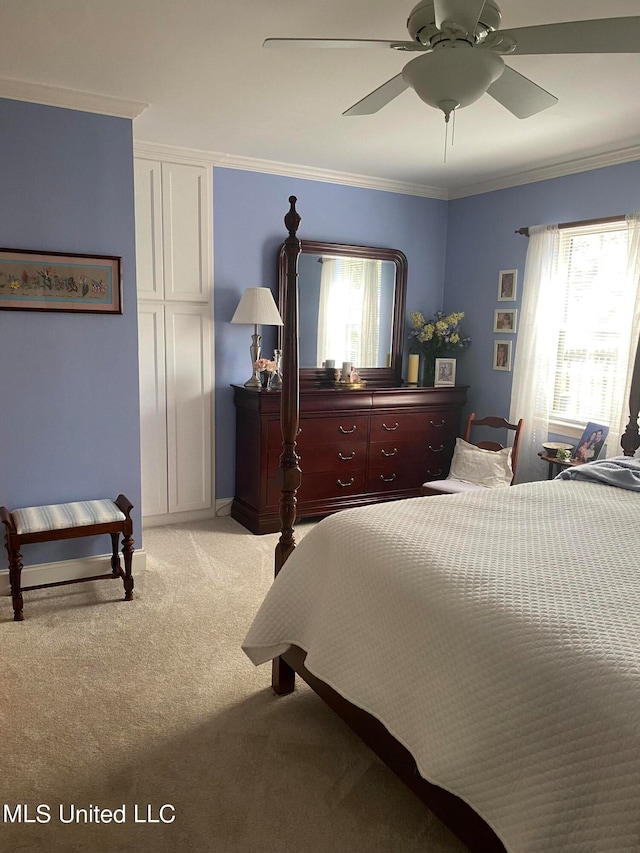 carpeted bedroom featuring multiple windows, ceiling fan, and ornamental molding