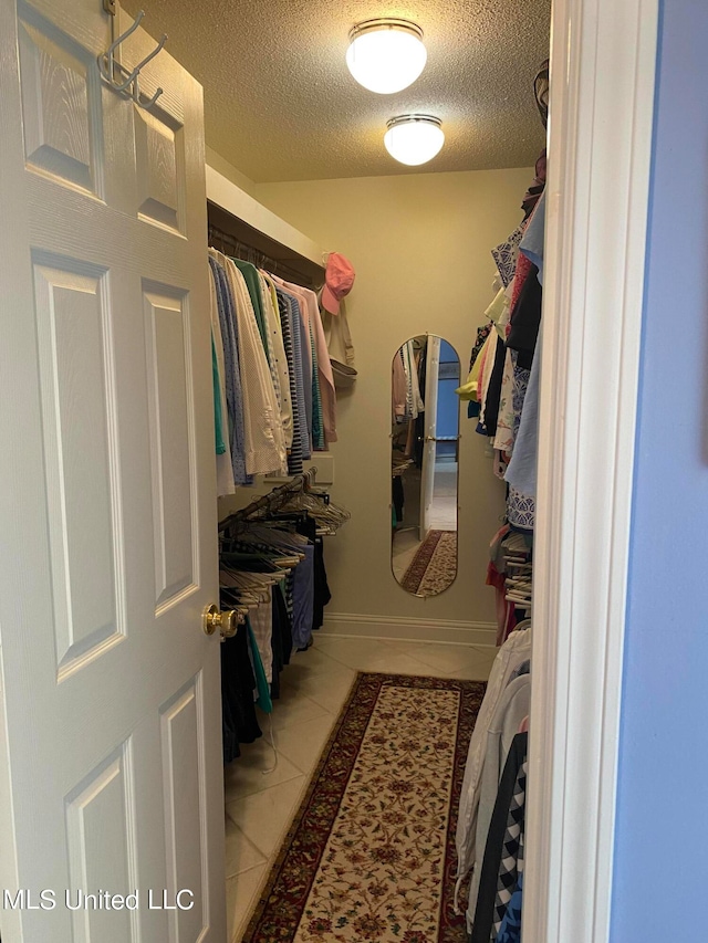 walk in closet featuring light tile patterned flooring