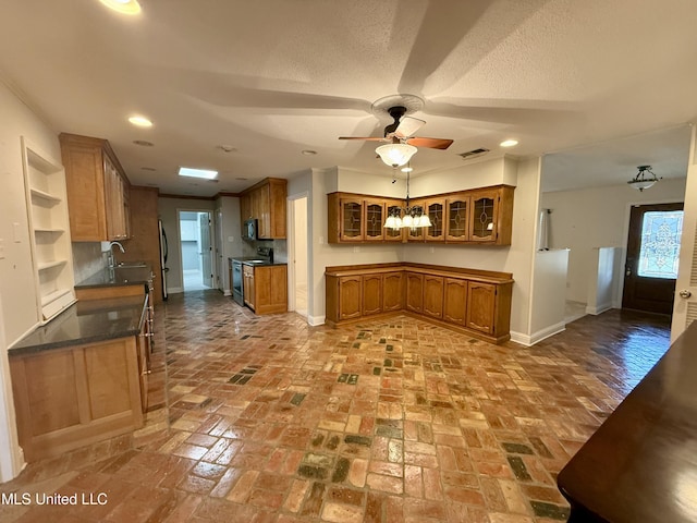 kitchen featuring brown cabinetry, a ceiling fan, baseboards, and appliances with stainless steel finishes