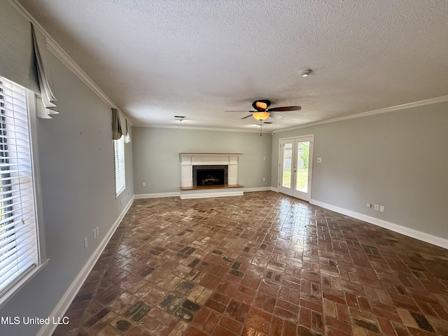 unfurnished living room featuring brick floor, a textured ceiling, a fireplace with raised hearth, and ceiling fan